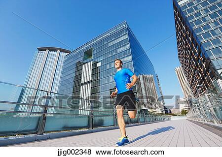Young Caucasian man running in metropolitan area View Large Photo Image Stock Photo - Young Caucasian man running in metropolitan area. Fotosearch