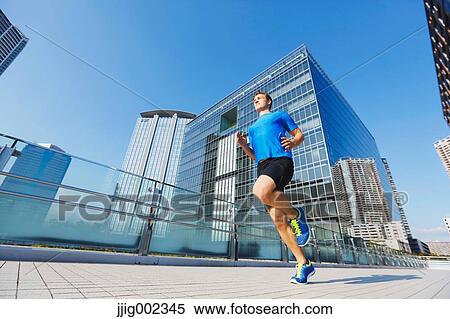 Young Caucasian man running in metropolitan area View Large Photo Image Stock Photography - Young Caucasian man running in metropolitan area. Fotosearch