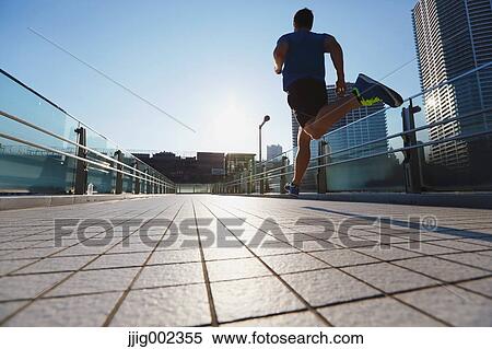 Young Caucasian man running in metropolitan area View Large Photo Image Stock Photography - Young Caucasian man running in metropolitan area. Fotosearch