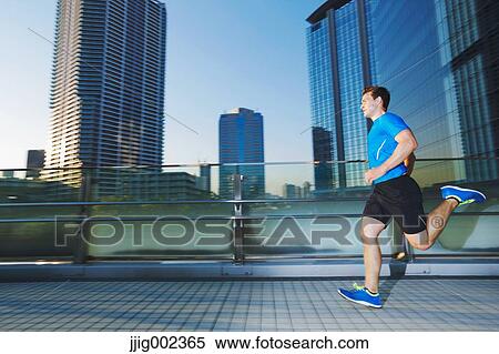 Stock Photography - Young Caucasian man running in metropolitan area. Fotosearch