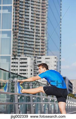 Young Caucasian man stretching in metropolitan area View Large Photo Image Stock Photo - Young Caucasian man stretching in metropolitan area. Fotosearch