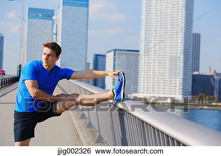 Young Caucasian man stretching in metropolitan area View Large Photo Image Stock Photograph - Young Caucasian man stretching in metropolitan area. Fotosearch