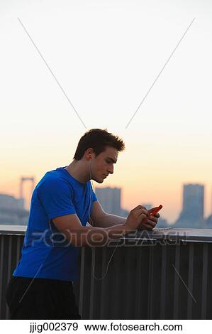Stock Photo - Young Caucasian man wearing sport clothes in metropolitan area. Fotosearch