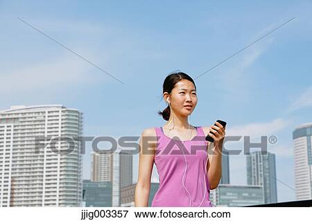 Young Japanese with smartphone during her run downtown Tokyo View Large Photo Image Stock Photo - Young Japanese with smartphone during her run downtown Tokyo. Fotosearch