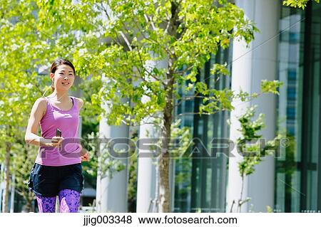 Stock Photo - Young Japanese woman running downtown Tokyo. Fotosearch