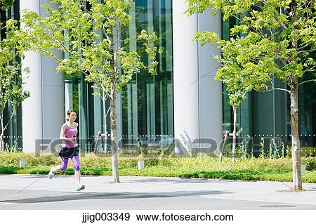 Stock Photo - Young Japanese woman running downtown Tokyo. Fotosearch