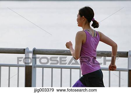 Stock Photo - Young Japanese woman running downtown Tokyo. Fotosearch