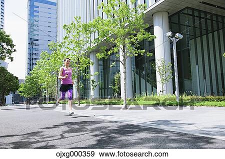 Stock Photo - Young Japanese woman running downtown Tokyo. Fotosearch