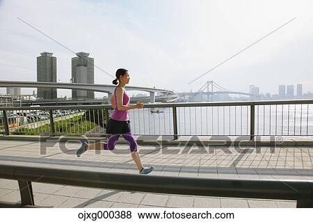 Young Japanese woman running downtown Tokyo View Large Photo Image Stock Photo - Young Japanese woman running downtown Tokyo. Fotosearch