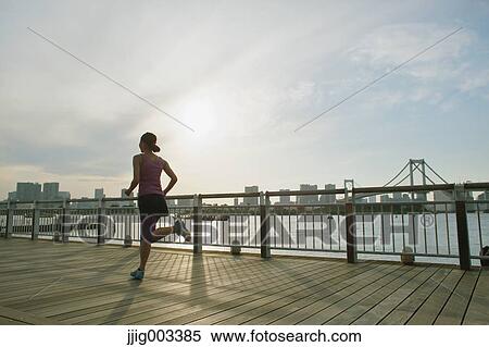 Stock Photography - Young Japanese woman running downtown Tokyo. Fotosearch