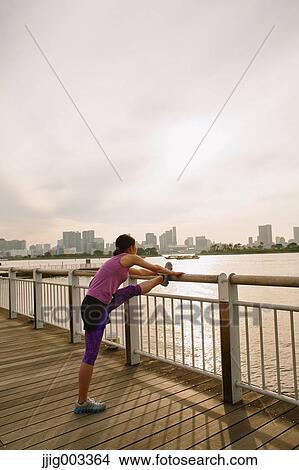 Young Japanese woman stretching before her run downtown Tokyo View Large Photo Image Picture - Young Japanese woman stretching before her run downtown Tokyo. Fotosearch