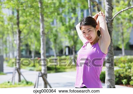 Young Japanese woman stretching before her run downtown Tokyo View Large Photo Image Picture - Young Japanese woman stretching before her run downtown Tokyo. Fotosearch