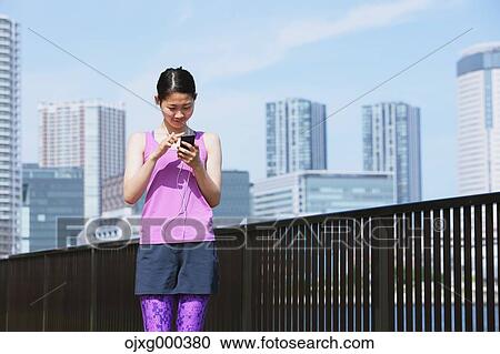 Young Japanese woman with smartphone before her run downtown Tokyo View Large Photo Image Stock Image - Young Japanese woman with smartphone before her run downtown Tokyo. Fotosearch