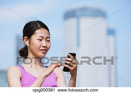Young Japanese woman with smartphone before her run downtown Tokyo View Large Photo Image Stock Image - Young Japanese woman with smartphone before her run downtown Tokyo. Fotosearch