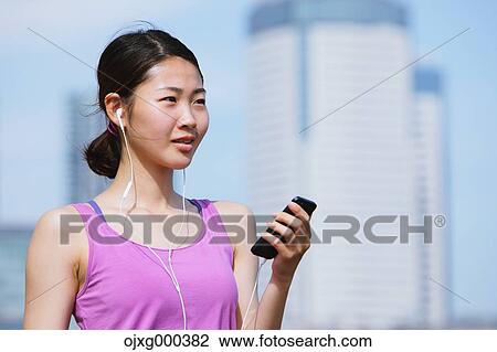 Young Japanese woman with smartphone before her run downtown Tokyo View Large Photo Image Stock Image - Young Japanese woman with smartphone before her run downtown Tokyo. Fotosearch