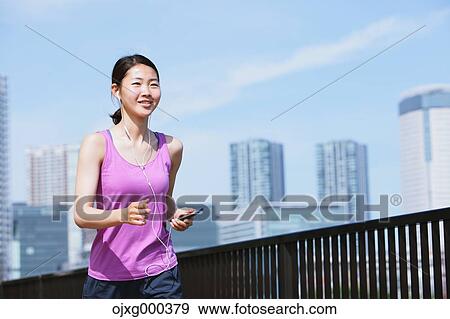 Young Japanese woman with smartphone before her run downtown Tokyo View Large Photo Image Stock Photo - Young Japanese woman with smartphone before her run downtown Tokyo. Fotosearch