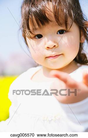 Young smiling Japanese girl enjoying cherry blossoms in a city park View Large Photo Image Stock Image - Young smiling Japanese girl enjoying cherry blossoms in a city park. Fotosearch