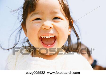 Young smiling Japanese girl enjoying cherry blossoms in a city park View Large Photo Image Stock Image - Young smiling Japanese girl enjoying cherry blossoms in a city park. Fotosearch