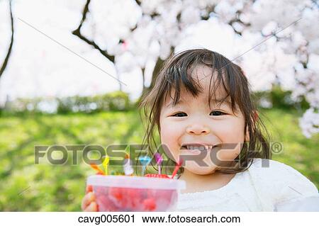 Young smiling Japanese girl enjoying cherry blossoms in a city park View Large Photo Image Stock Image - Young smiling Japanese girl enjoying cherry blossoms in a city park. Fotosearch