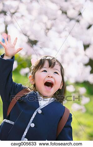 Young smiling Japanese girl enjoying cherry blossoms in a city park View Large Photo Image Stock Image - Young smiling Japanese girl enjoying cherry blossoms in a city park. Fotosearch