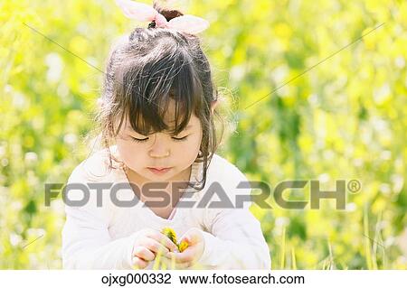 Young smiling Japanese girl enjoying cherry blossoms in a city park View Large Photo Image Stock Image - Young smiling Japanese girl enjoying cherry blossoms in a city park. Fotosearch