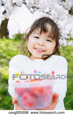 Young smiling Japanese girl enjoying cherry blossoms in a city park View Large Photo Image Stock Photo - Young smiling Japanese girl enjoying cherry blossoms in a city park. Fotosearch