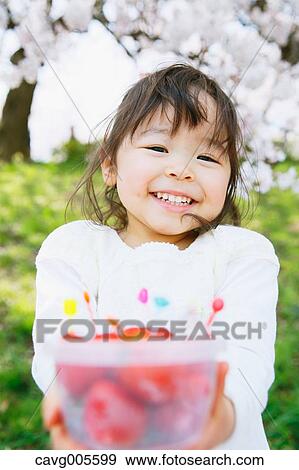 Young smiling Japanese girl enjoying cherry blossoms in a city park View Large Photo Image Stock Photo - Young smiling Japanese girl enjoying cherry blossoms in a city park. Fotosearch