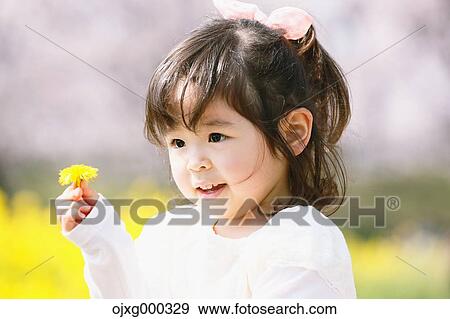 Young smiling Japanese girl enjoying cherry blossoms in a city park View Large Photo Image Stock Photo - Young smiling Japanese girl enjoying cherry blossoms in a city park. Fotosearch