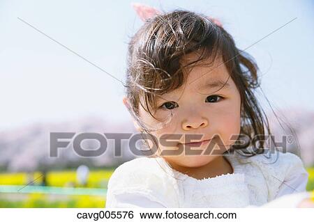 Young smiling Japanese girl enjoying cherry blossoms in a city park View Large Photo Image Stock Photograph - Young smiling Japanese girl enjoying cherry blossoms in a city park. Fotosearch