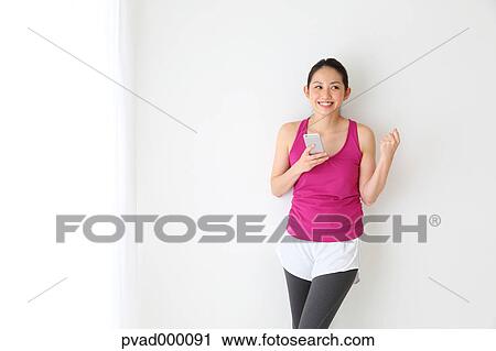 Attractive Japanese woman relaxing after training in a airy room View Large Photo Image Stock Image - Attractive Japanese woman relaxing after training in a airy room. Fotosearch