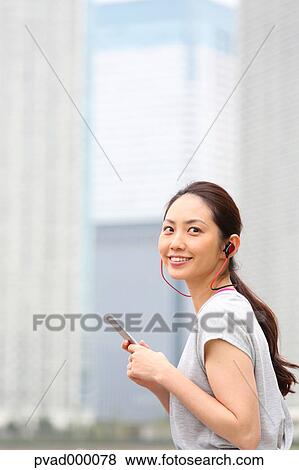 Attractive Japanese woman relaxing after training by a river downtown Tokyo, Japan View Large Photo Image Stock Photo - Attractive Japanese woman relaxing after training by a river downtown Tokyo, Japan. Fotosearch