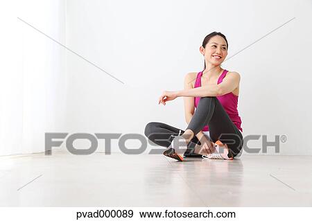 Attractive Japanese woman relaxing after training in a airy room View Large Photo Image Stock Photo - Attractive Japanese woman relaxing after training in a airy room. Fotosearch