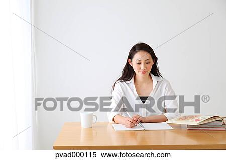 Attractive Japanese woman sitting at a table in a airy room View Large Photo Image Stock Photography - Attractive Japanese woman sitting at a table in a airy room. Fotosearch