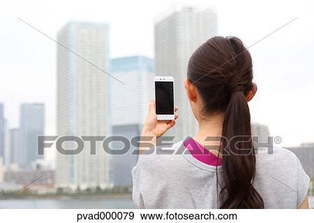 Attractive Japanese woman taking pictures by a river downtown Tokyo, Japan View Large Photo Image Stock Photo - Attractive Japanese woman taking pictures by a river downtown Tokyo, Japan. Fotosearch