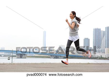 Attractive Japanese woman training by a river downtown Tokyo, Japan View Large Photo Image Picture - Attractive Japanese woman training by a river downtown Tokyo, Japan. Fotosearch