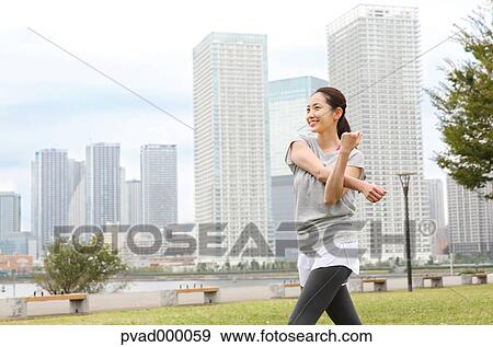 Attractive Japanese woman training by a river downtown Tokyo, Japan View Large Photo Image Stock Photo - Attractive Japanese woman training by a river downtown Tokyo, Japan. Fotosearch