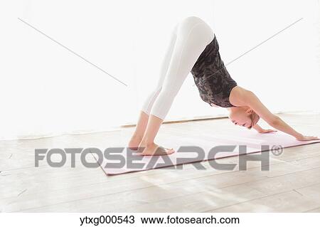 Stock Image - Attractive young Japanese practicing yoga in an airy room. Fotosearch