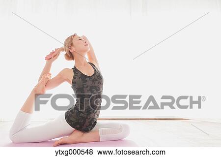Attractive young Japanese practicing yoga in an airy room View Large Photo Image Stock Photo - Attractive young Japanese practicing yoga in an airy room. Fotosearch
