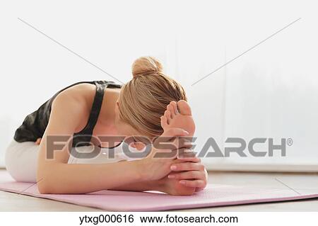 Stock Photograph - Attractive young Japanese practicing yoga in an airy room. Fotosearch