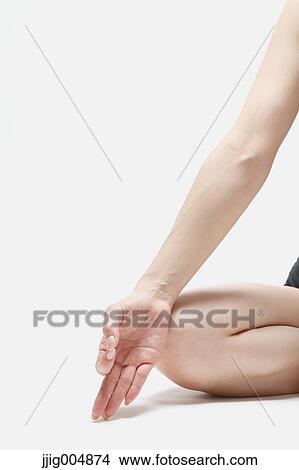 Picture - Attractive young Japanese woman wearing black pants and tank top practicing yoga on white background. Fotosearch