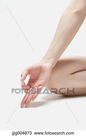 Stock Image - Attractive young Japanese woman wearing black pants and tank top practicing yoga on white background. Fotosearch