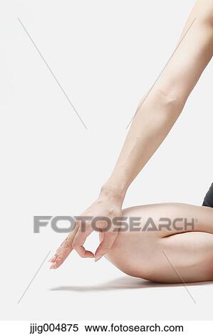 Stock Photography - Attractive young Japanese woman wearing black pants and tank top practicing yoga on white background. Fotosearch
