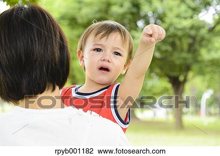 Crying kid on mum's shoulder View Large Photo Image Stock Image - Crying kid on mum's shoulder. Fotosearch