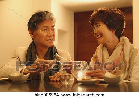 Fashionable Japanese senior couple having a good time at the restaurant View Large Photo Image Picture - Fashionable Japanese senior couple having a good time at the restaurant. Fotosearch