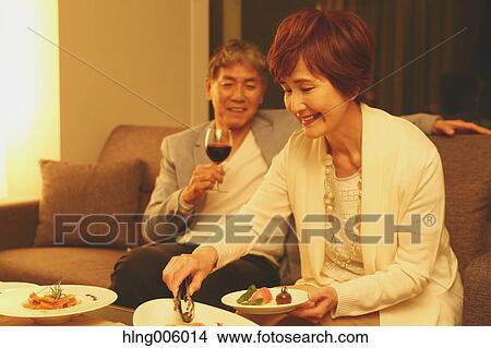 Fashionable Japanese senior couple toasting on sofa View Large Photo Image Picture - Fashionable Japanese senior couple toasting on sofa. Fotosearch
