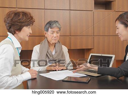 Fashionable Japanese senior couple discussing with advisor View Large Photo Image Stock Image - Fashionable Japanese senior couple discussing with advisor. Fotosearch
