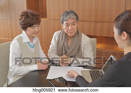 Fashionable Japanese senior couple discussing with advisor View Large Photo Image Stock Image - Fashionable Japanese senior couple discussing with advisor. Fotosearch