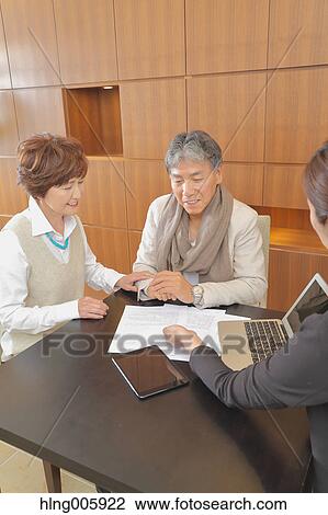 Fashionable Japanese senior couple discussing with advisor View Large Photo Image Stock Image - Fashionable Japanese senior couple discussing with advisor. Fotosearch
