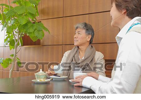 Fashionable Japanese senior couple enjoying a cup of coffee View Large Photo Image Stock Photo - Fashionable Japanese senior couple enjoying a cup of coffee. Fotosearch