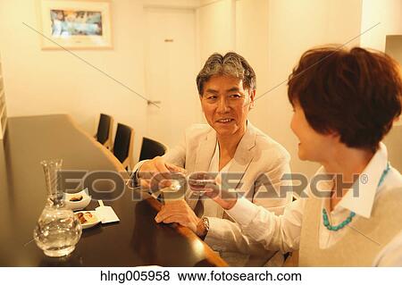 Fashionable Japanese senior couple having a good time at the restaurant View Large Photo Image Stock Photo - Fashionable Japanese senior couple having a good time at the restaurant. Fotosearch